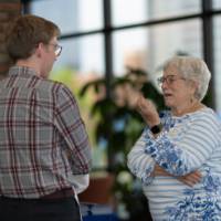 A group of guests talk and smile in the Eberhard lobby